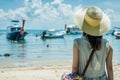 woman with widebrimmed hat and beach bag looking out at boats Royalty Free Stock Photo