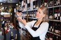 Woman wine producer inspecting quality of wine