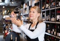 Woman wine producer inspecting quality of wine