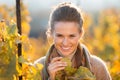 Woman winegrower inspecting grape vines in autumn vineyard