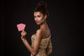 Woman winning - Young woman in a classy gold dress holding two cards, a poker of aces card combination.