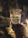 Woman in winter clothes holding glass of champagne in cove with glacier Royalty Free Stock Photo