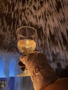 Woman in winter clothes holding glass of champagne in cove with glacier Royalty Free Stock Photo