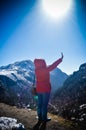 A woman in winter clothing standing on top of the rock of a snowcapped rocky mountain. Rear view. Deep Snow and Blizzard all Royalty Free Stock Photo