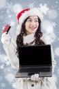 Woman in winter coat holding laptop and credit card Royalty Free Stock Photo