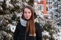 Woman in winter down jacket in winter park on background of snow-covered fir Royalty Free Stock Photo