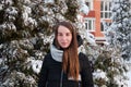 Woman in winter down jacket in winter park on background of snow-covered fir Royalty Free Stock Photo