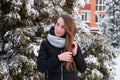 Woman in winter down jacket in winter park on background of snow-covered fir Royalty Free Stock Photo