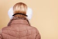 Woman in winter earmuffs and jacket back