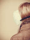 Woman in winter earmuffs and jacket back