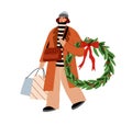 Woman after winter holiday shopping. Happy person carrying bags, walking with Christmas wreath, festive purchases