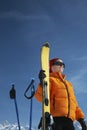 Woman In Winter Jacket Holding Ski Against Blue Sky