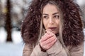 Woman in winter snow day blow on her cold hands close-up