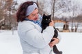 Woman at winter snowy day at walk with a cat Royalty Free Stock Photo