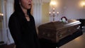 Woman with wipe and coffin at funeral in church