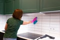 Woman wipes tiles in the kitchen. Cleaning employee cleans the house. Royalty Free Stock Photo