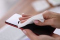 Woman wiping mobile phone with antistatic cloth at home closeup