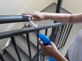 Woman wiping railings in staircase