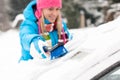 Woman wiping snow car window using brush Royalty Free Stock Photo