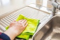 Woman is wiping the water from the drainer