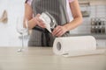 Woman wiping wine glass with paper towel in kitchen Royalty Free Stock Photo