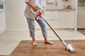 Woman with a wireless portable vacuum cleaner in the kitchen. Cleans Royalty Free Stock Photo