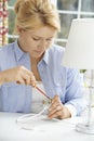 Woman Wiring Electrical Plug On Lamp At Home