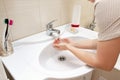 A woman wishing hands with water in bathroom sink. Desease prevention and hygiene concept. Useful, good habit