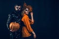 Woman witch with Pumpkin and Handsome bearded man. Enjoying nice Halloween together.