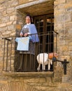 Woman witch and sheep on a balcony hanging clothes.