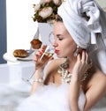 Woman witn soft big towel in the motning take breakfast in hotel spa lying in bath tub drinking glass of champagne Royalty Free Stock Photo