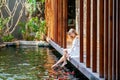 Woman on wooden bridge in Japanese garden feeding fish Royalty Free Stock Photo