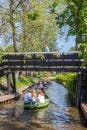 Woman on a wooden bridge overlooking the boats in Giethoorn