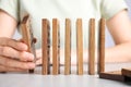 Woman with wooden dominoes at white table, closeup Royalty Free Stock Photo