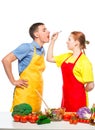 woman with a wooden spoon feeds a man a useful vegetable salad on a white