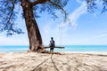 Woman on wooden swing under tree on the beach in phuket thailand