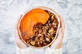 Woman in woolen sweater holding bowl with cinnamon granola, coconut yogurt, chia seeds and pumpkin puree. Healthy vegan smoothie Royalty Free Stock Photo