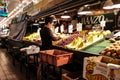 Woman worker arranges fruit on Manzo Brothers stand at Pike Place Market