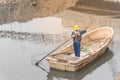 Woman worker on the boat cleaning up a polluted river in Hanoi, Vietnam Royalty Free Stock Photo