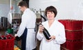 Woman worker displaying wine bottle Royalty Free Stock Photo