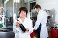 Woman worker displaying wine bottle Royalty Free Stock Photo