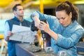 woman worker drilling in metalworks factory