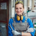 Woman worker in her metal workshop posing with tools