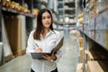 Woman worker holding clipboard and checking inventory in the warehouse store Royalty Free Stock Photo