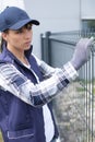 woman worker installing welded metal mesh fence Royalty Free Stock Photo