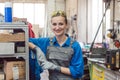 Woman worker in metal workshop looking into camera