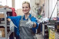 Woman worker in metal workshop showing thumbs-up Royalty Free Stock Photo