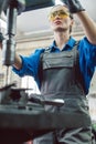 Woman worker in metal workshop using pedestal drill Royalty Free Stock Photo