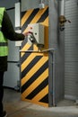 A woman worker presses the button to open the roller shutter doors at an industrial enterprise Royalty Free Stock Photo