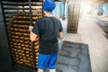 Woman worker puts trays with biscuits in large industrial oven, confectionery factory, biscuit production